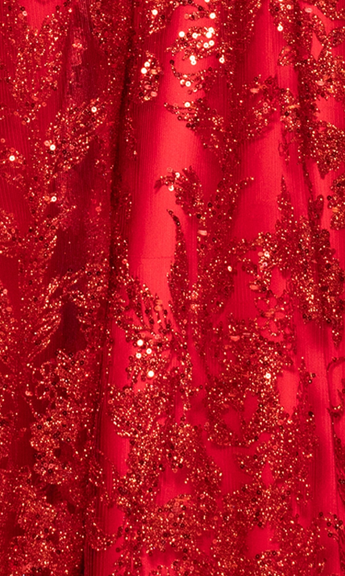 Close-up of red fabric with intricate glittery sequins and floral designs from the Long Glitter Prom Dress: Blondie Nites 5501BN—ideal for a sparkling evening gown or prom look.